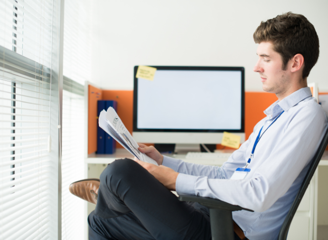 man sitting reading a document in an office