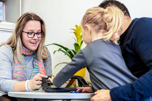 two adults working with a child